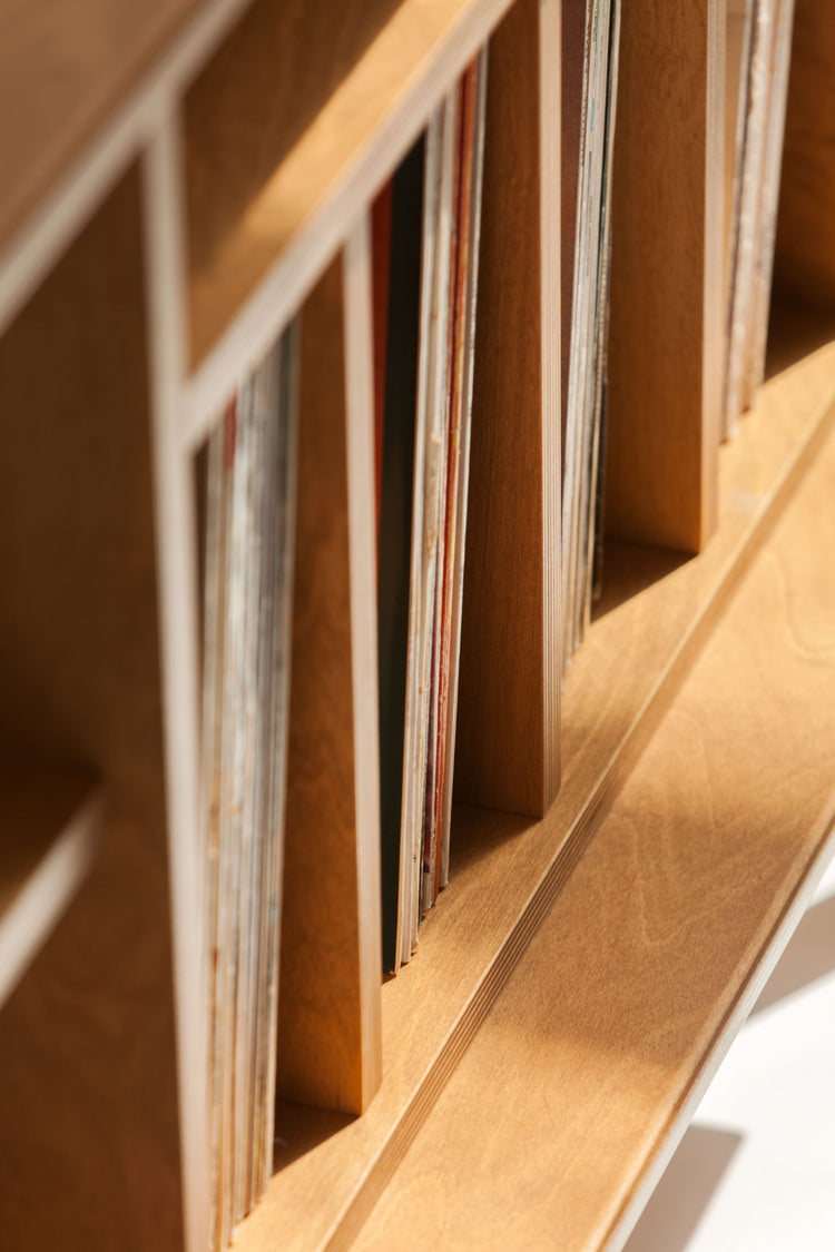 Close-up of a wooden bookshelf with vinyls inside