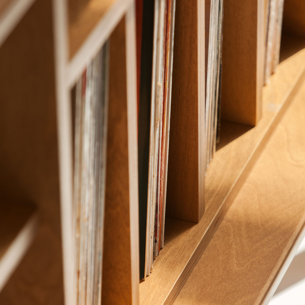 Close-up of a wooden bookshelf with vinyls inside