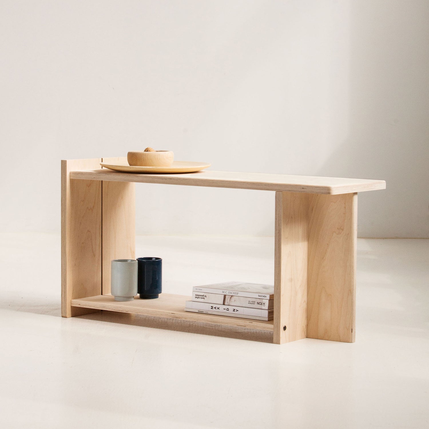 Minimalist wooden bench with a few items on a plain background