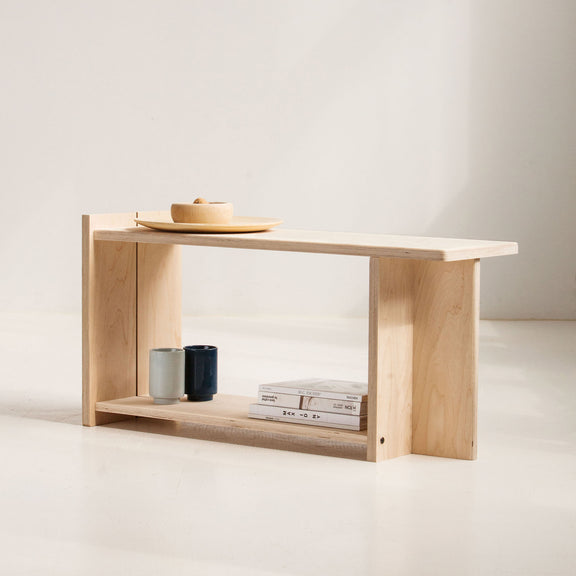 Minimalist wooden bench with a few items on a plain background