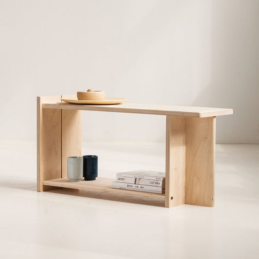 Minimalist wooden bench with a few items on a plain background