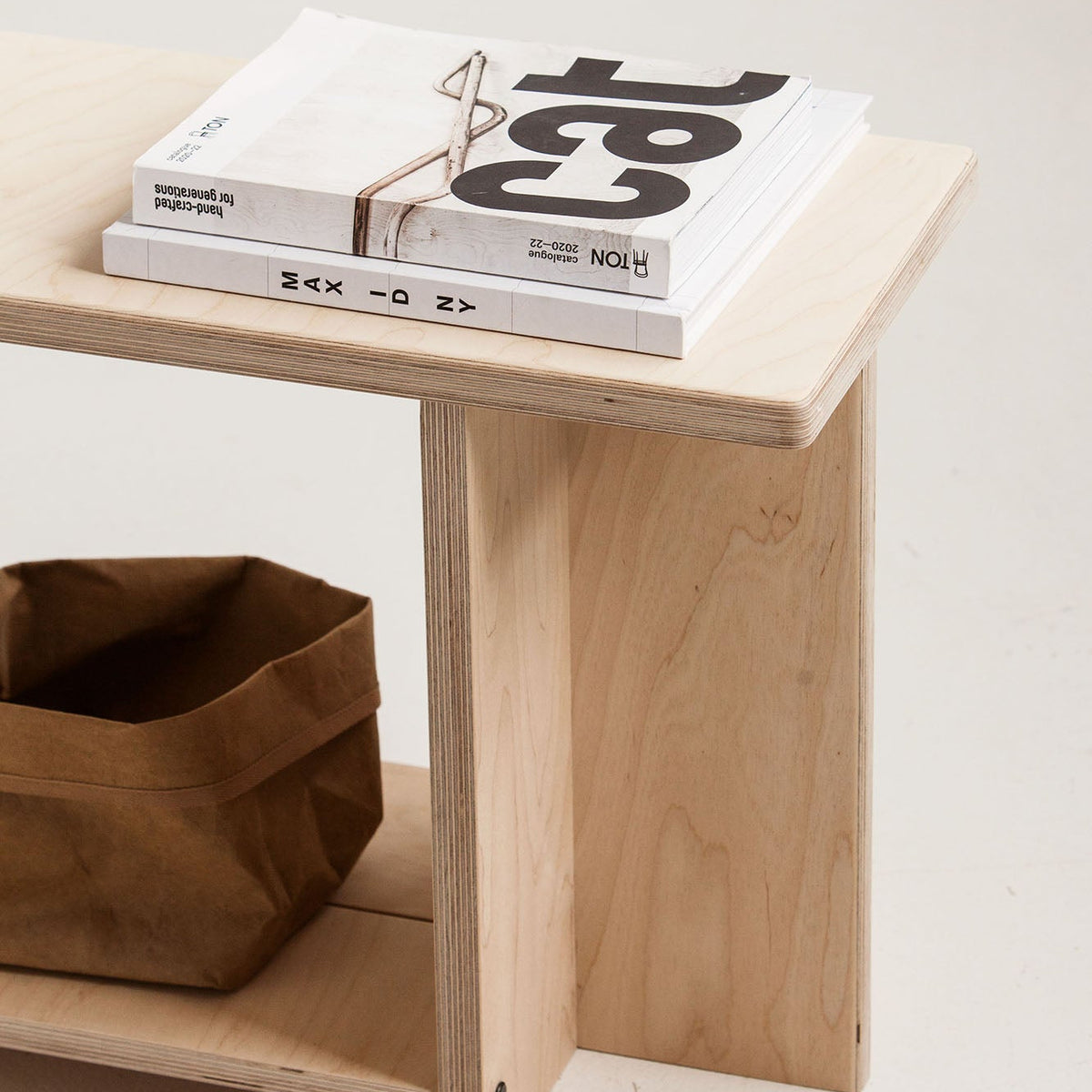 Wooden bench with books and a bag on a light background