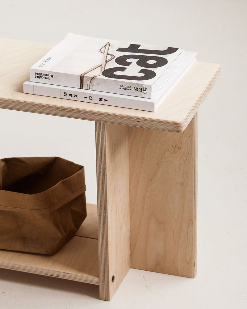 Wooden bench with books and a bag on a light background