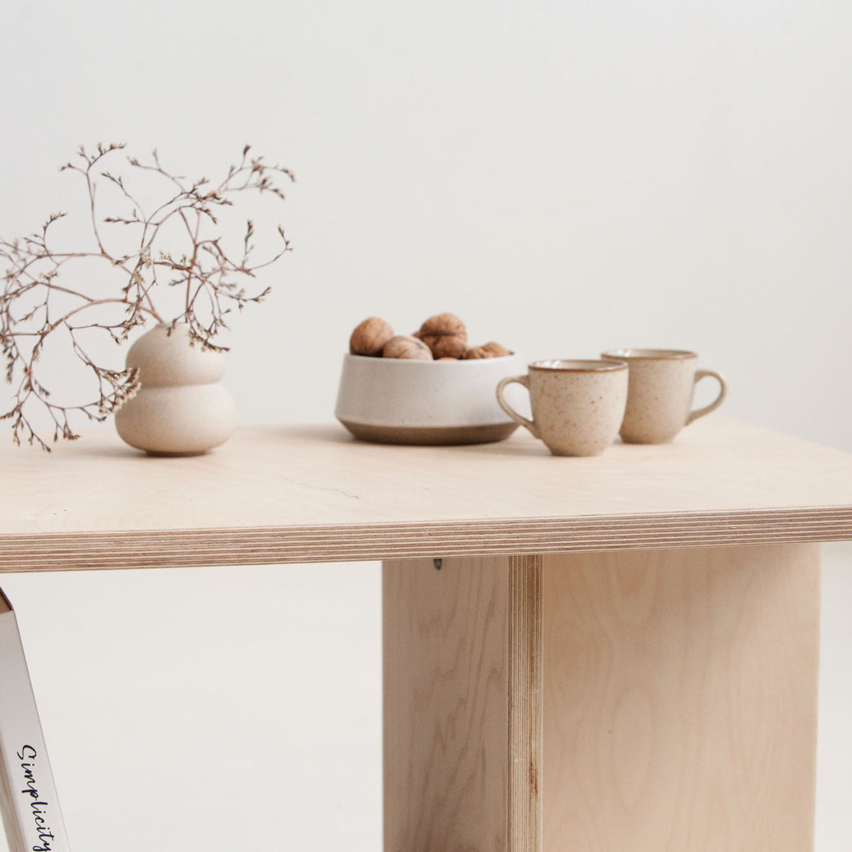 Minimalist wooden table with decorative items on a plain background