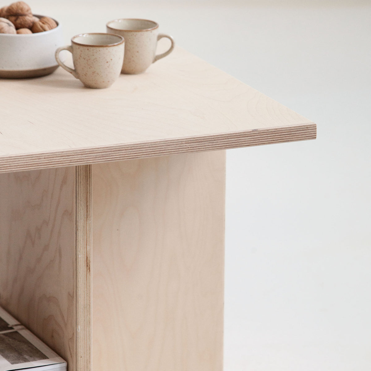 Light wooden desk with two ceramic cups on a white background
