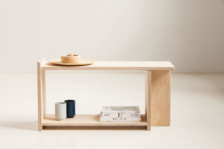 Minimalist wooden bench with a few items on a plain background