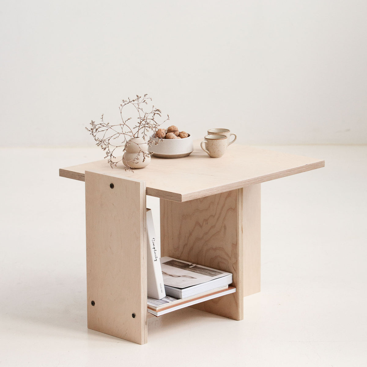 Small wooden table with decorative items on a white background