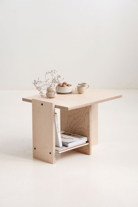 Small wooden table with decorative items on a white background